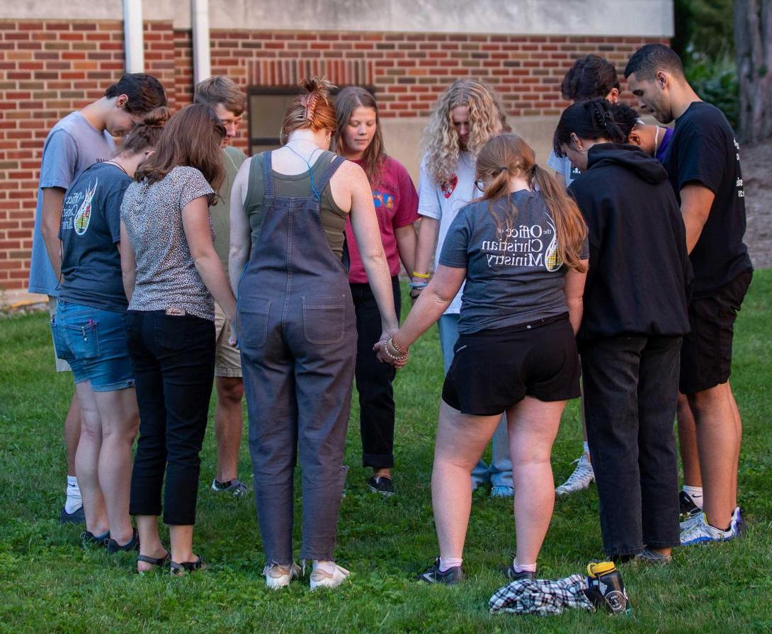 一群学生站成一圈祈祷